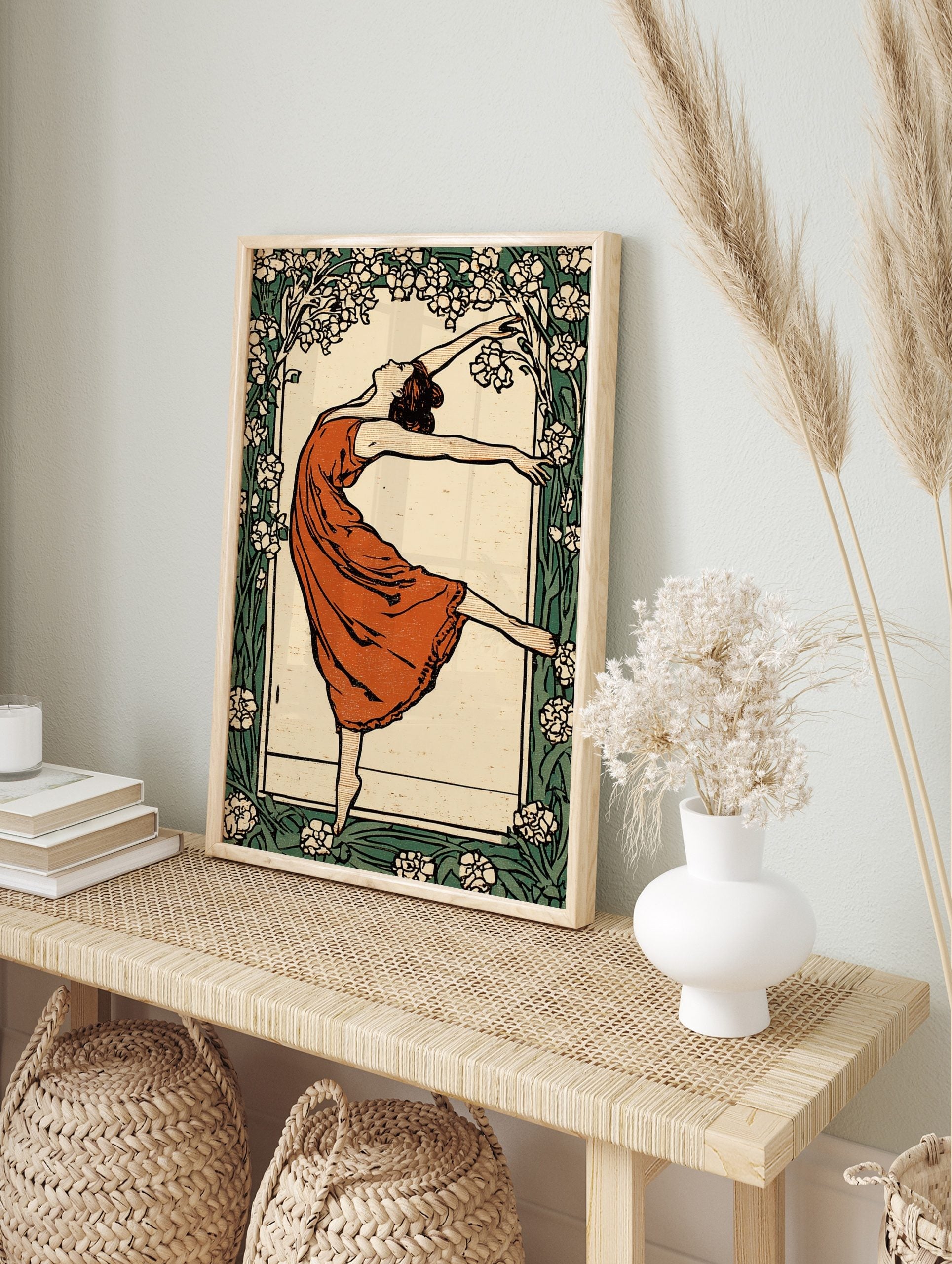 Art Nouveau dancer in terracotta dress, arms outstretched, framed by white and green floral, in an alternate framed mockup