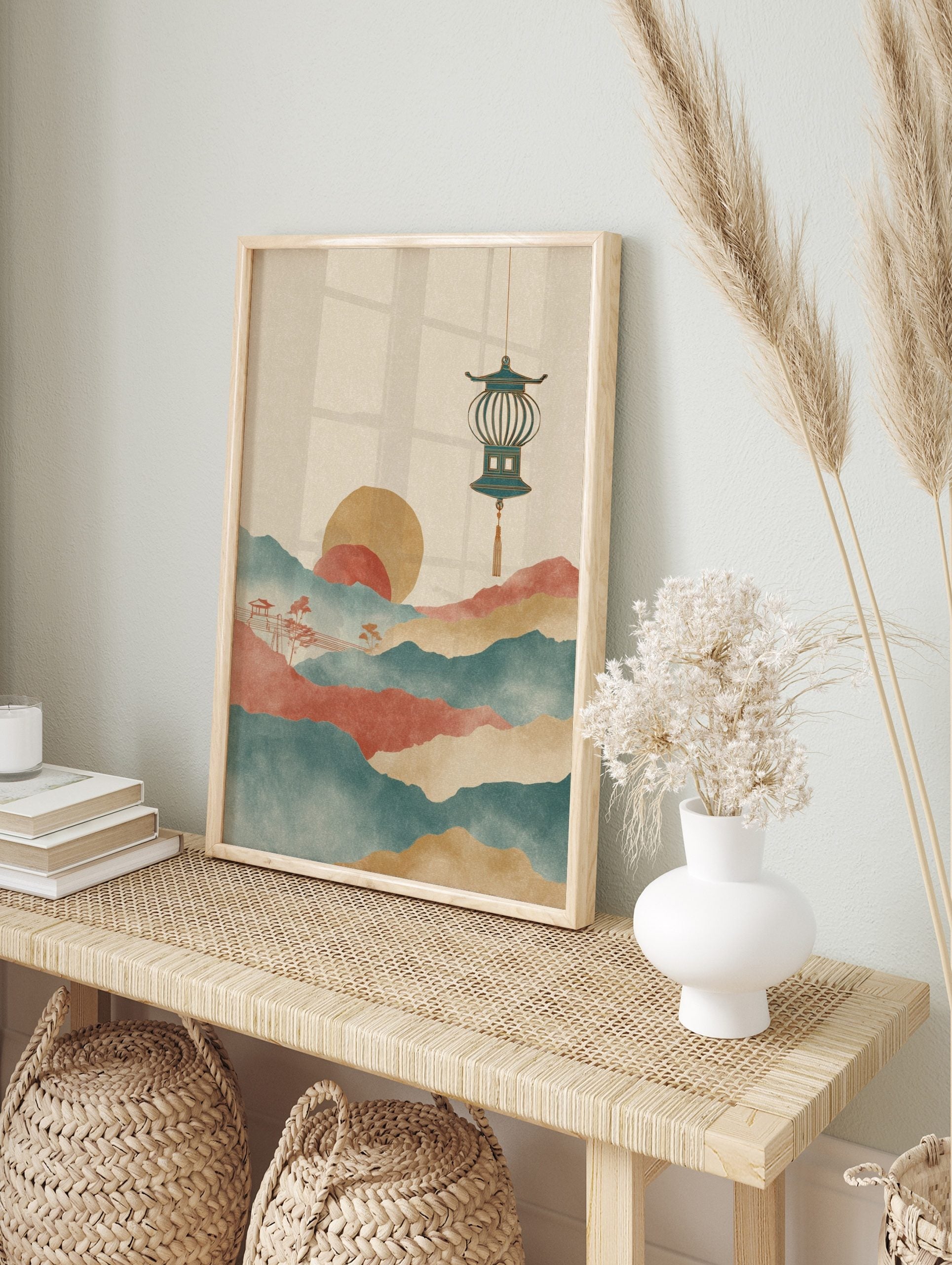 Stylised Asian landscape art print with layered teal and red mountains, golden sun, and, in an alternate framed mockup