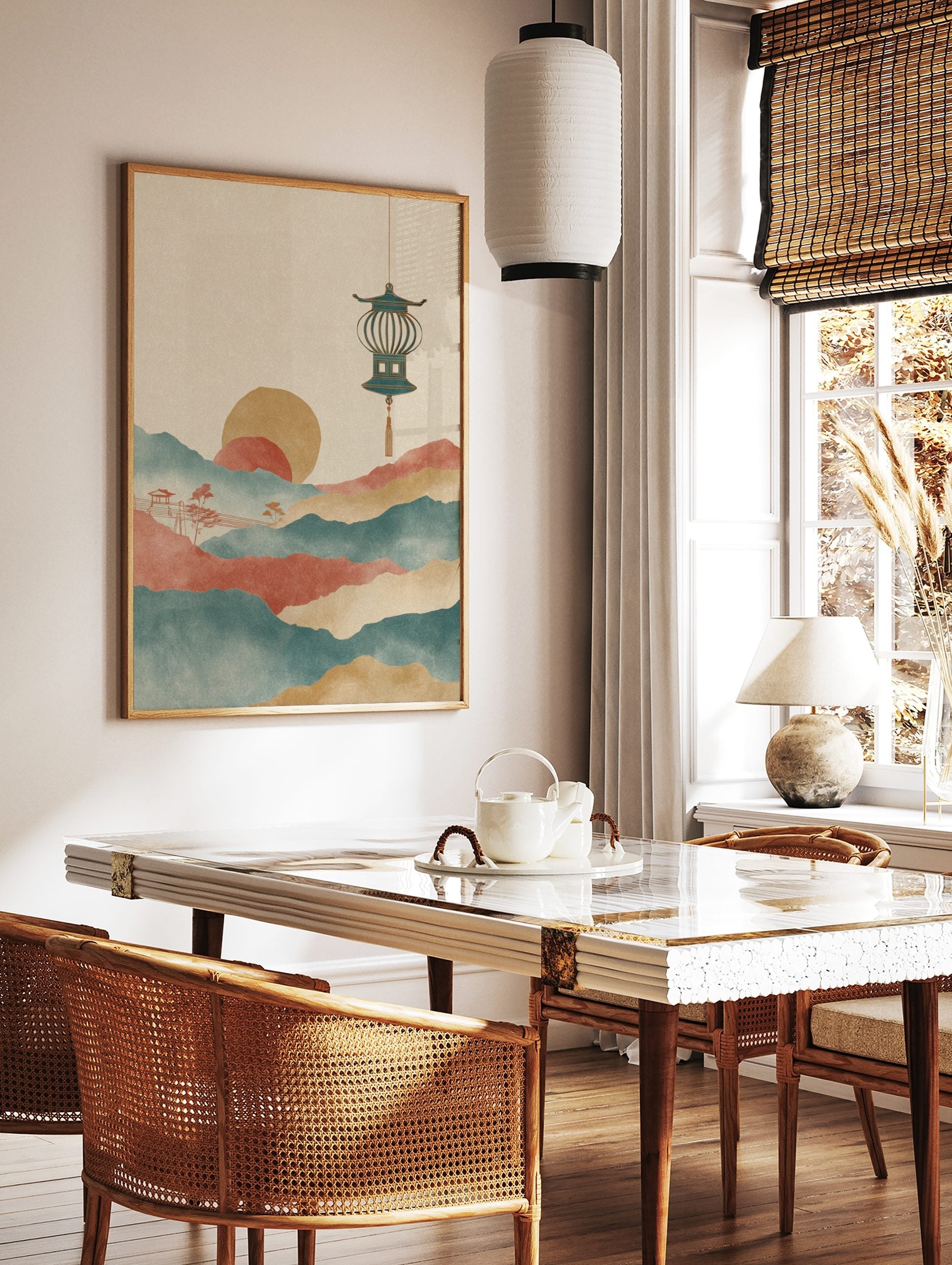 Stylised Asian landscape art print with layered teal and red mountains, golden sun, and hanging, in a styled room mockup