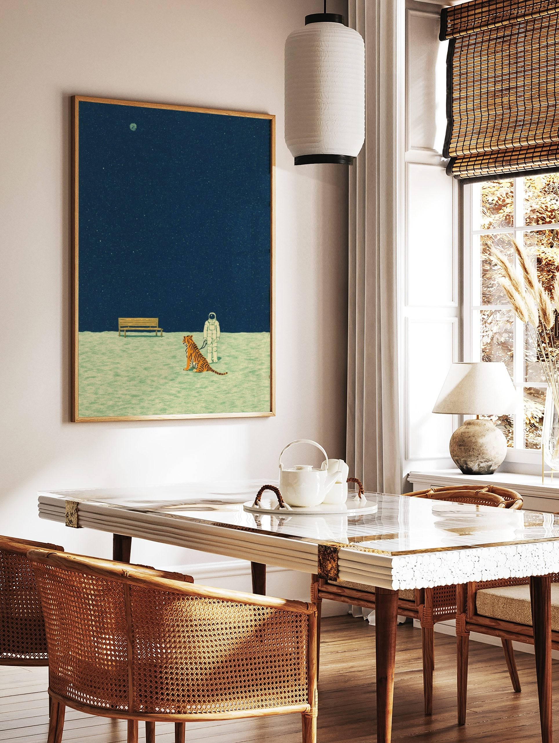 Illustrative print of astronaut on leash with tiger, wooden bench, dark blue starry sky, and, in a styled room mockup