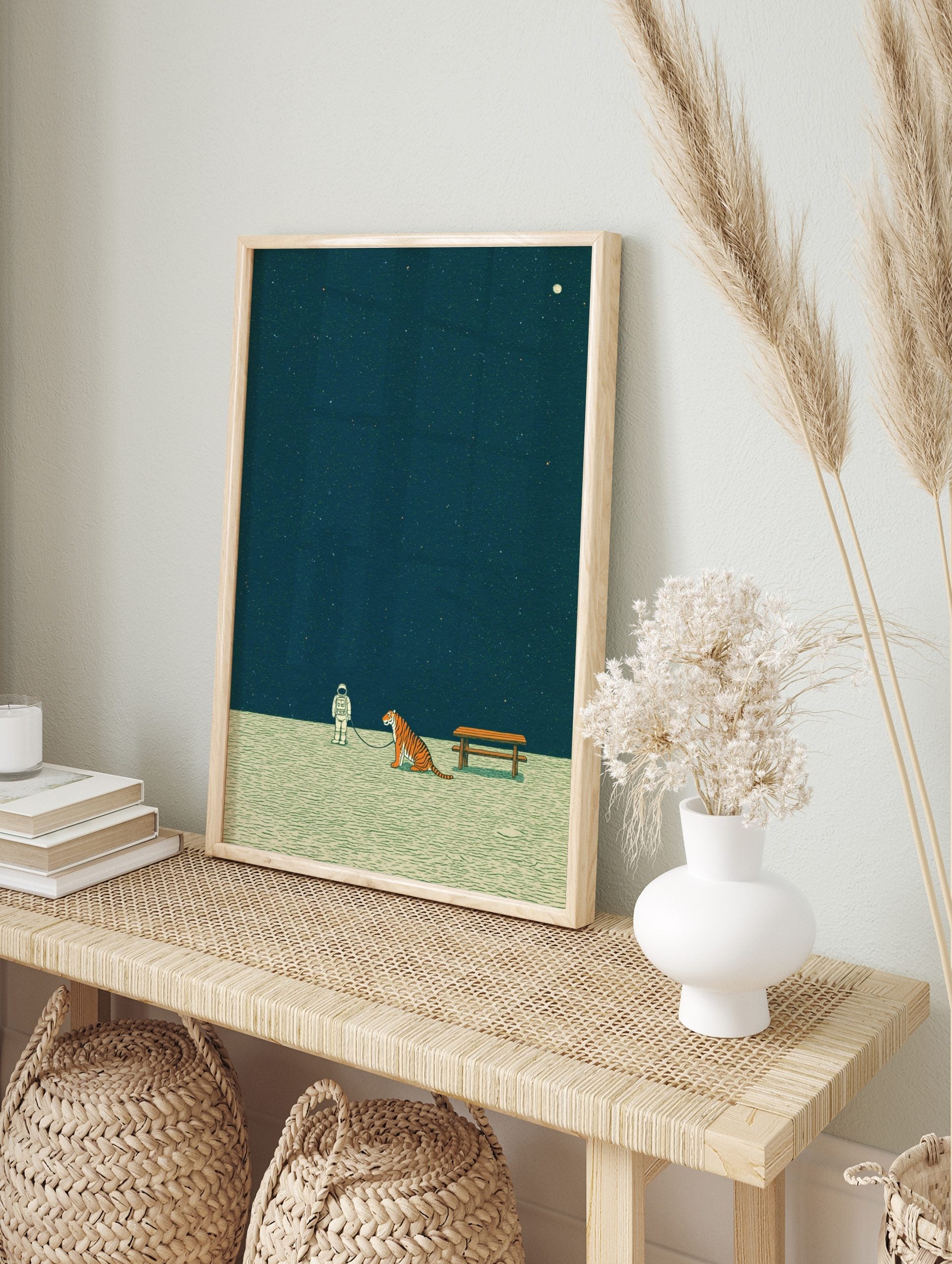 Illustrative print of an astronaut walking a tiger on a leash under a dark, starry sky with a, in an alternate framed mockup