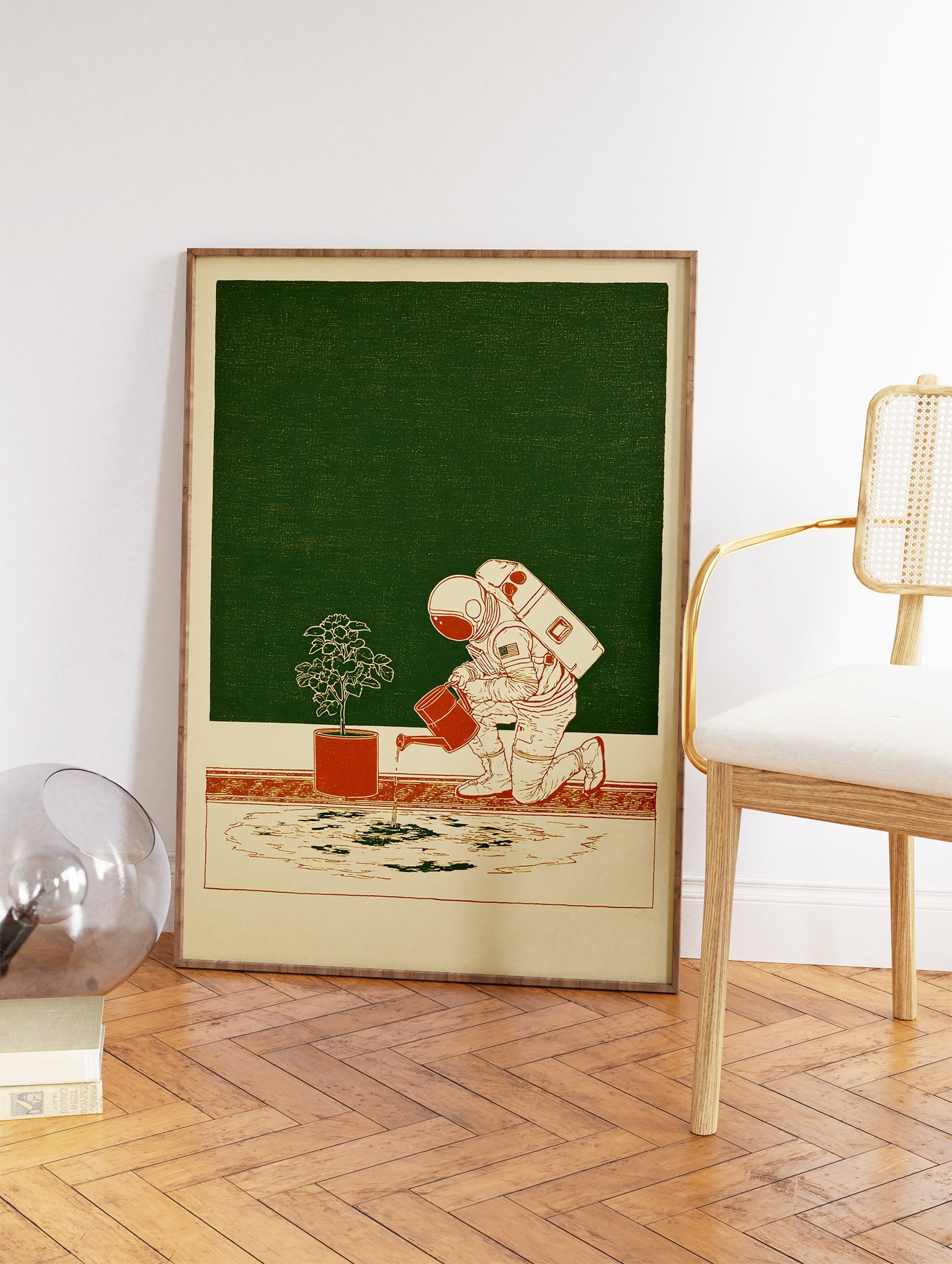Astronaut wall art illustration showing an astronaut in a spacesuit watering a small potted plant on a beige floor. - Image 2