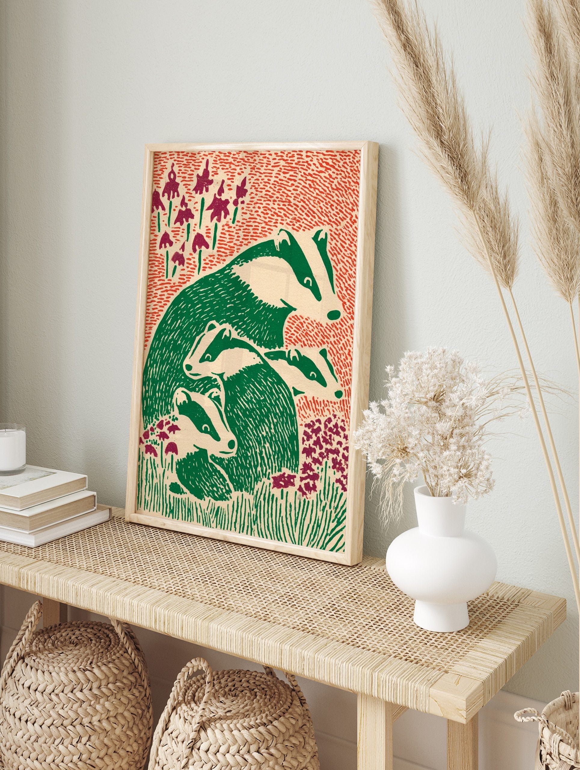 Illustrative print of an adult badger and three young badgers in green and off-white, in an alternate framed mockup