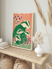 Illustrative print of an adult badger and three young badgers in green and off-white, in an alternate framed mockup