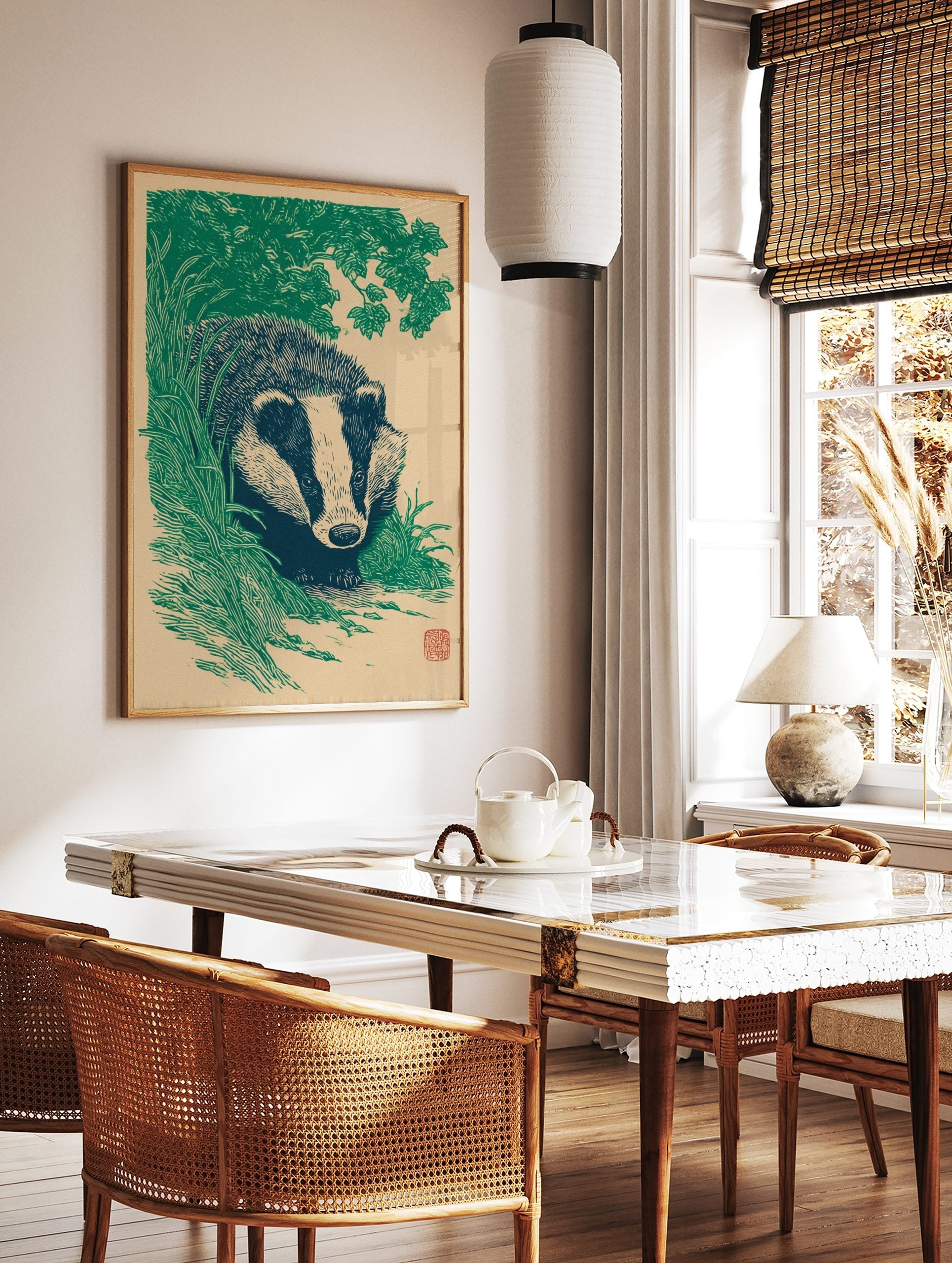 Illustrative linocut style print of a badger peeking through green foliage on a beige background, in a styled room mockup