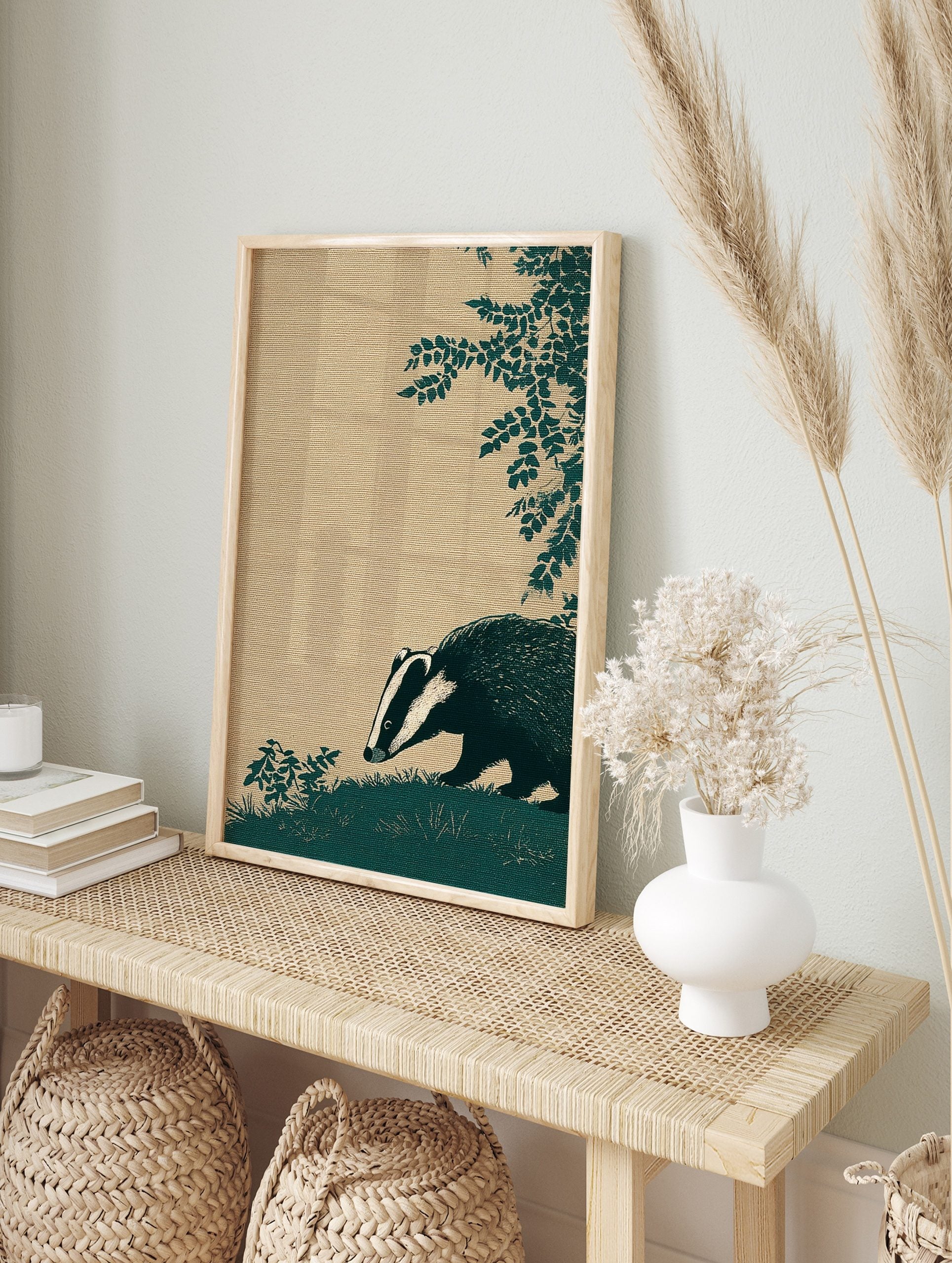Illustrative dark teal badger with white stripes sniffing grass, textured beige background, in an alternate framed mockup
