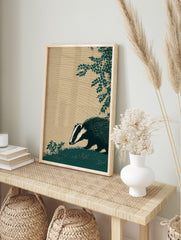 Illustrative dark teal badger with white stripes sniffing grass, textured beige background, in an alternate framed mockup