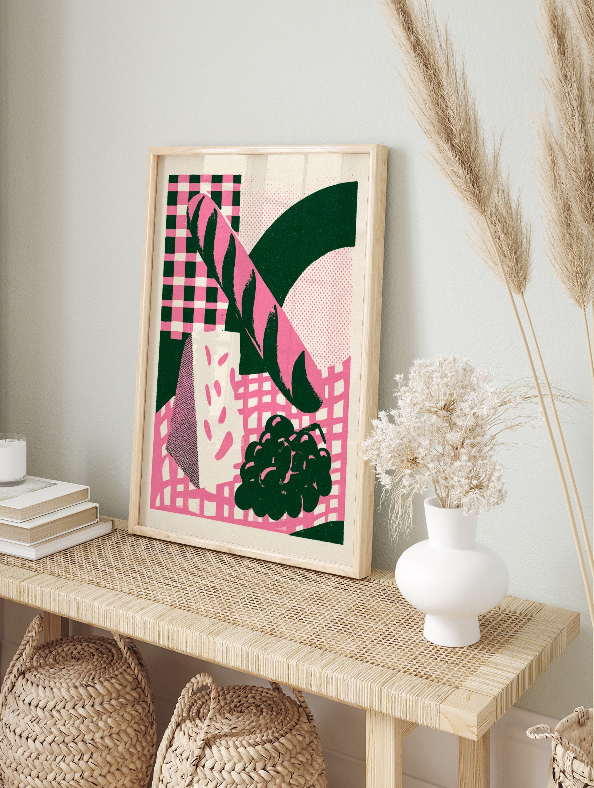 Retro illustration of a baguette, cheese, and grapes in pink and dark green on a checkerboard, in an alternate framed mockup