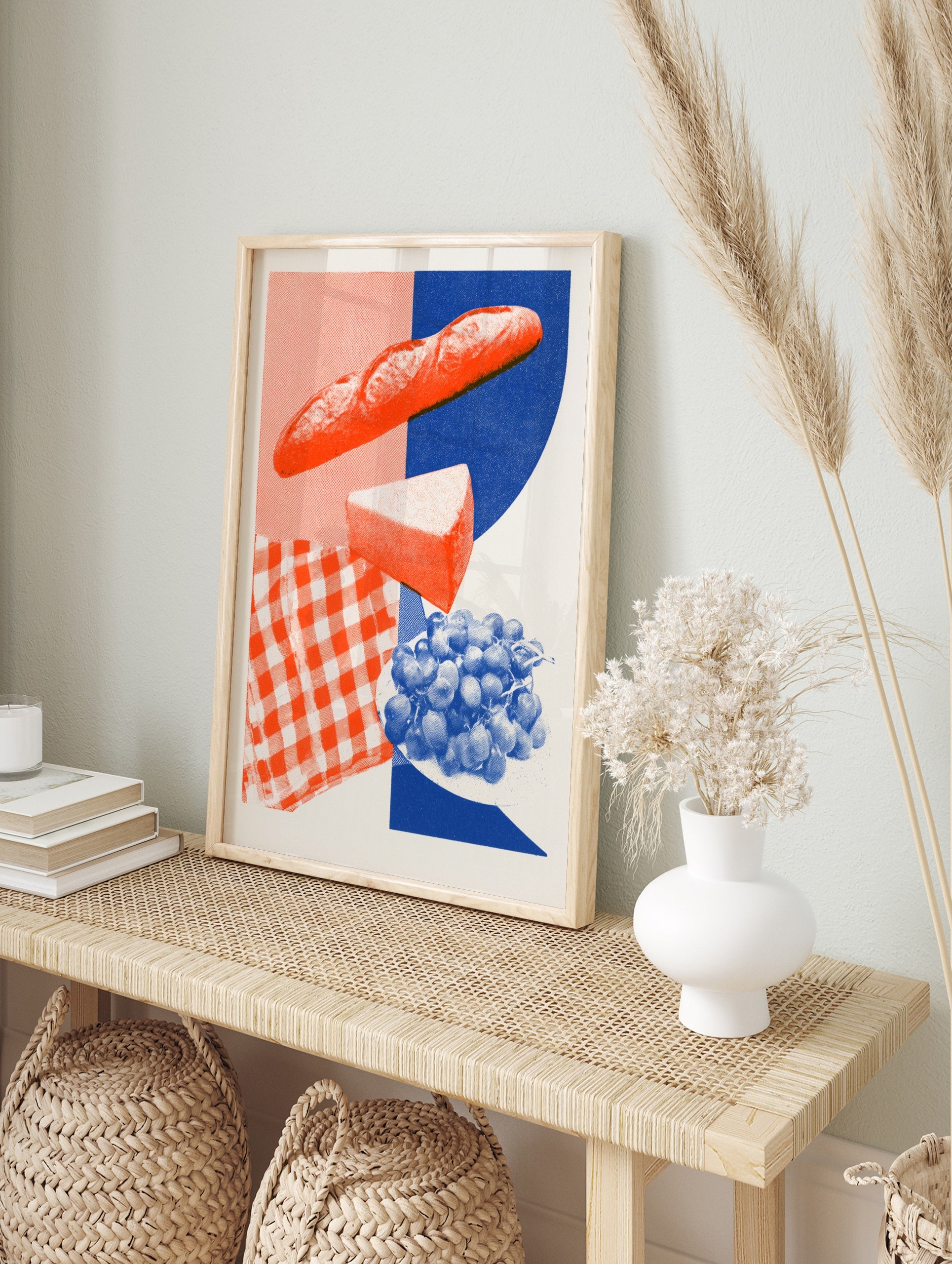 Graphic food illustration of a baguette, cheese and grapes with a red gingham and blue, in an alternate framed mockup