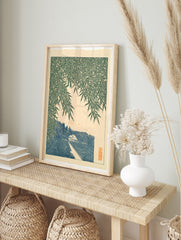 Japanese-style art print showing bamboo leaves over a path, a small house, and a mountain, in an alternate framed mockup