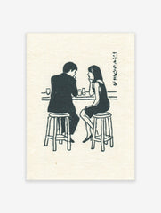 Illustrative print of a man and woman talking at a bar counter with glasses and Japanese text