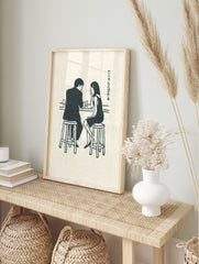 Illustrative print of a man and woman talking at a bar counter with glasses and Japanese text, in an alternate framed mockup