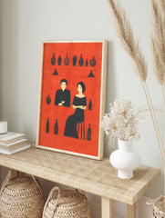 Minimalist bar scene art print with a man and woman in black silhouettes against a red, in an alternate framed mockup