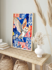 Barn owl with spread wings against a blue and coral collage background with floral patterns, in an alternate framed mockup