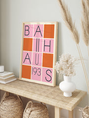 Bauhaus poster with a grid design featuring black letters spelling 'BAUHAUS 193S' on pink squares, interspersed with solid orange squares. - Image 4