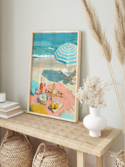 Impressionist painting of a beach picnic with rosé wine, fruit, a striped umbrella, and ocean, in an alternate framed mockup