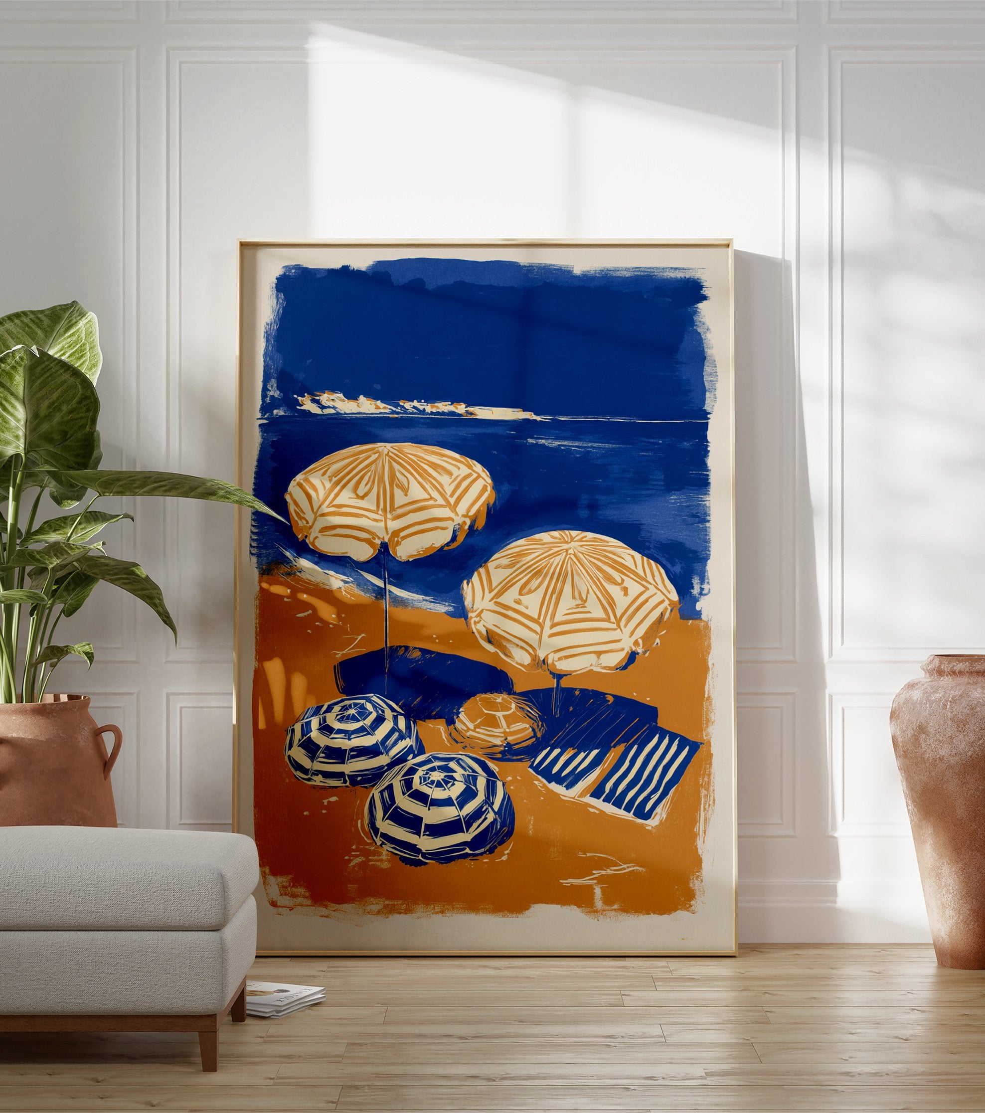 Blue and orange beach scene poster with two open umbrellas, two closed umbrellas, and a striped towel on the sand next to the ocean. - Image 3