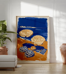 Blue and orange beach scene poster with two open umbrellas, two closed umbrellas, and a striped towel on the sand next to the ocean. - Image 3