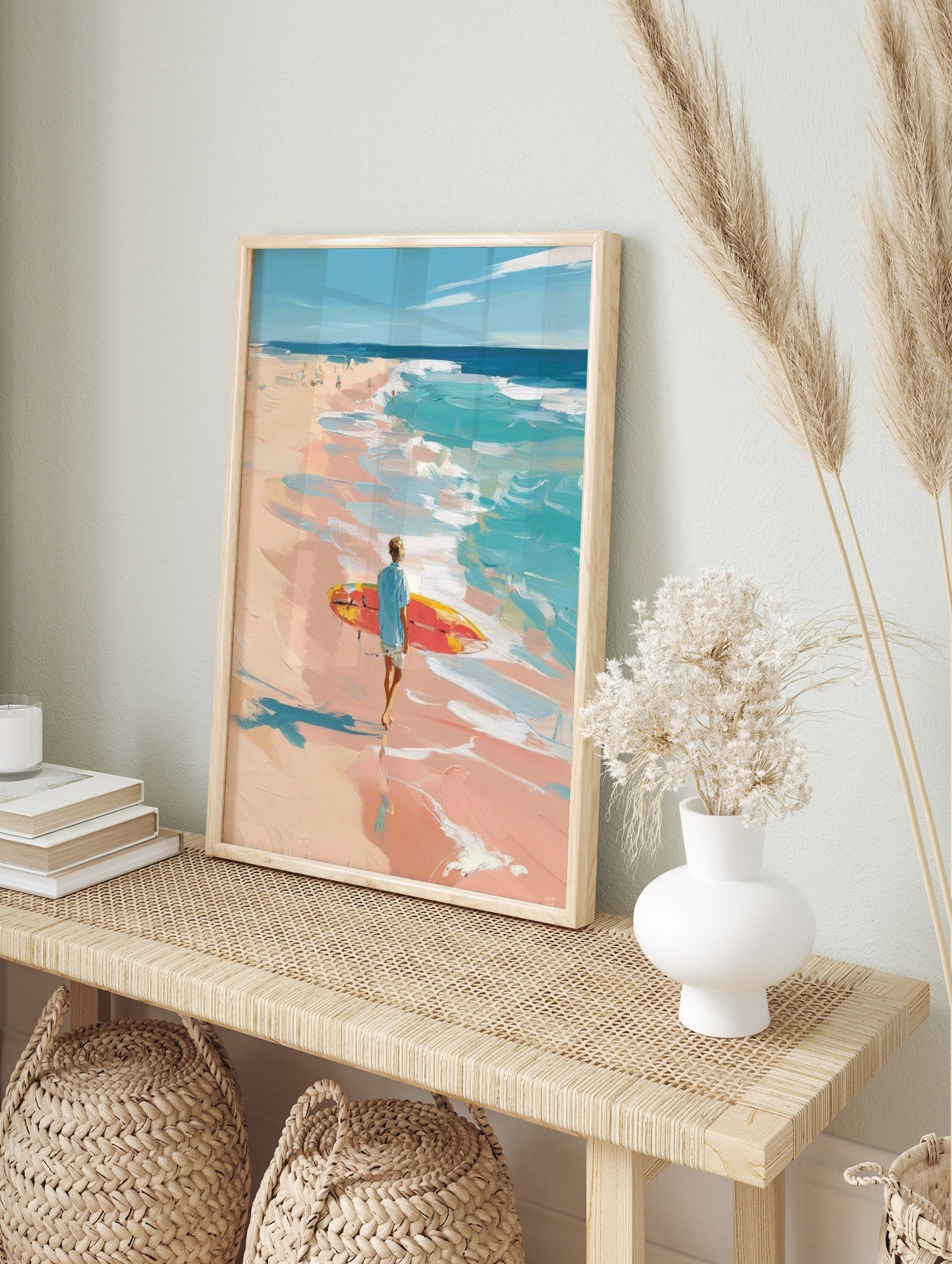 Impressionist painting of a surfer with red and yellow board walking on a peach-toned beach, in an alternate framed mockup