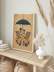 Illustrative beach scene with navy blue umbrella, striped deck chairs, and stylised blue, in an alternate framed mockup