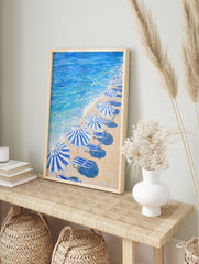 Blue Beach Umbrellas poster showing a painting of a sandy beach with striped umbrellas, lounge chairs, and blue ocean waves. - Image 4