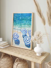 Blue and white striped beach umbrellas poster on a sandy beach next to turquoise ocean waves. - Image 4
