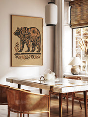 Stylised bear wall art print with botanical patterns in dark brown and beige on a sandy background, in a styled room mockup