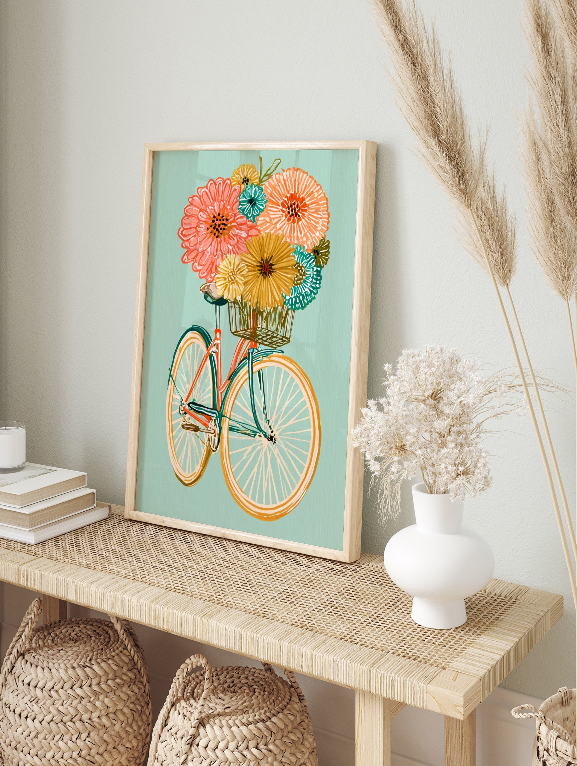 Illustrative bicycle with an orange frame and basket full of colourful flowers on a soft teal, in an alternate framed mockup