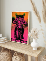 Neon pink and green biker cat poster with aviator goggles, motorcycle, and the text Chase, in an alternate framed mockup