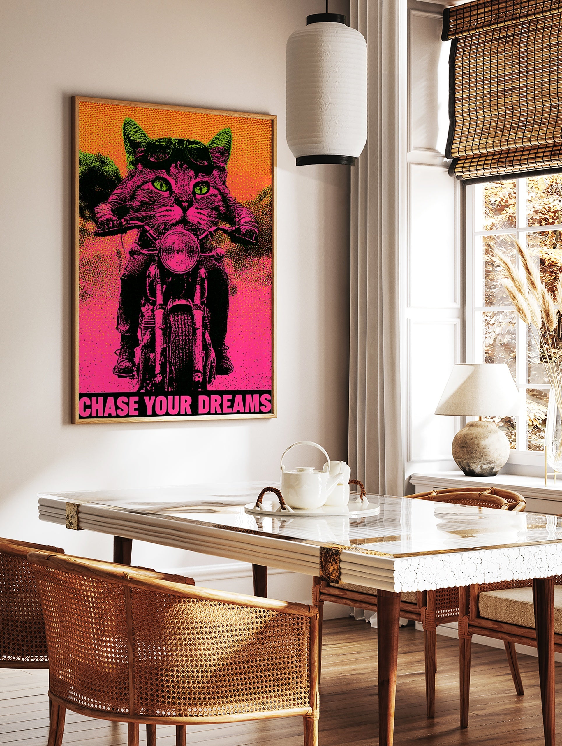 Neon pink and green biker cat poster with aviator goggles, motorcycle, and the text Chase Your, in a styled room mockup