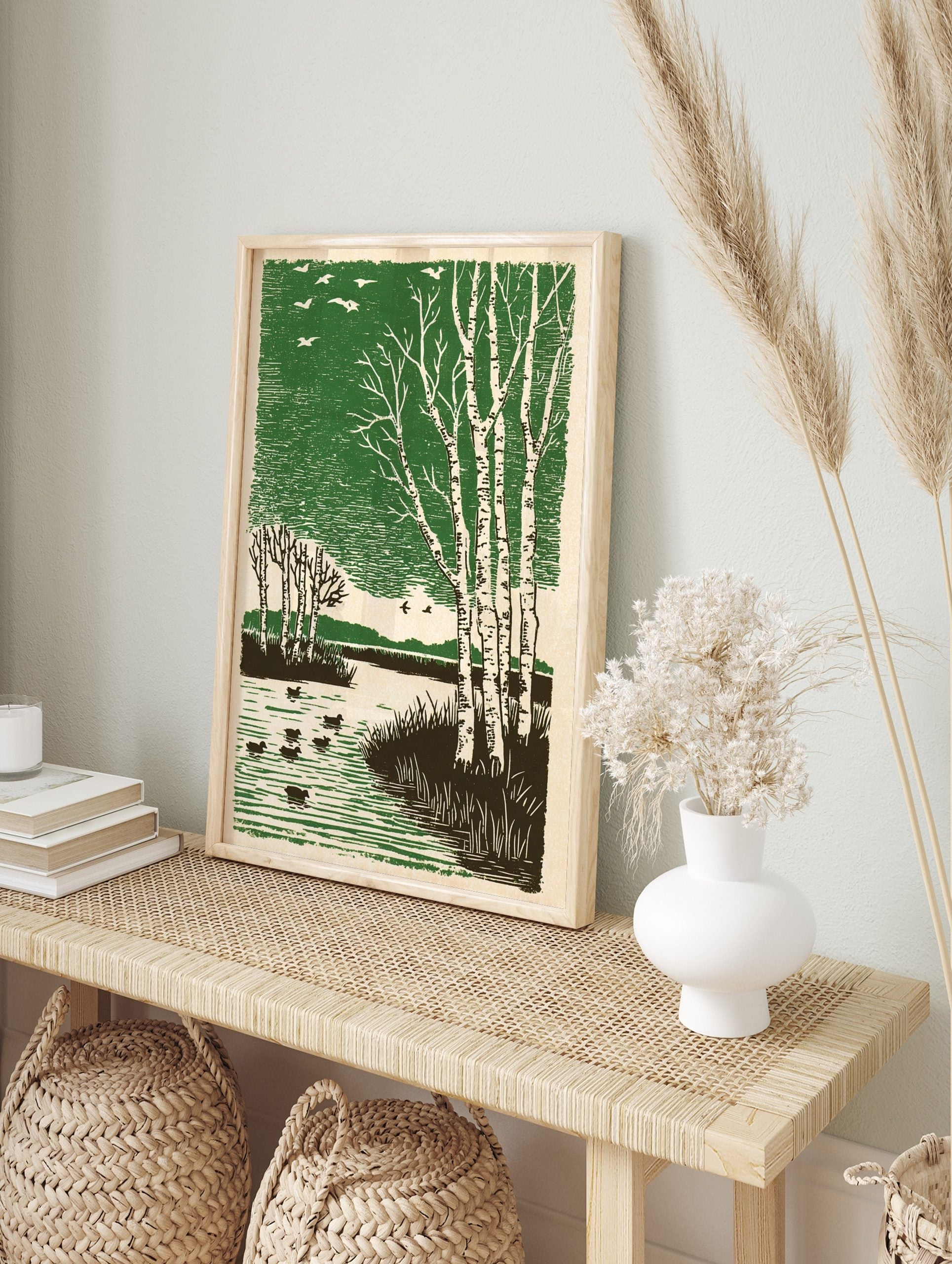 Illustrative art print of birch trees, ducks, and birds in a serene green and brown lake, in an alternate framed mockup