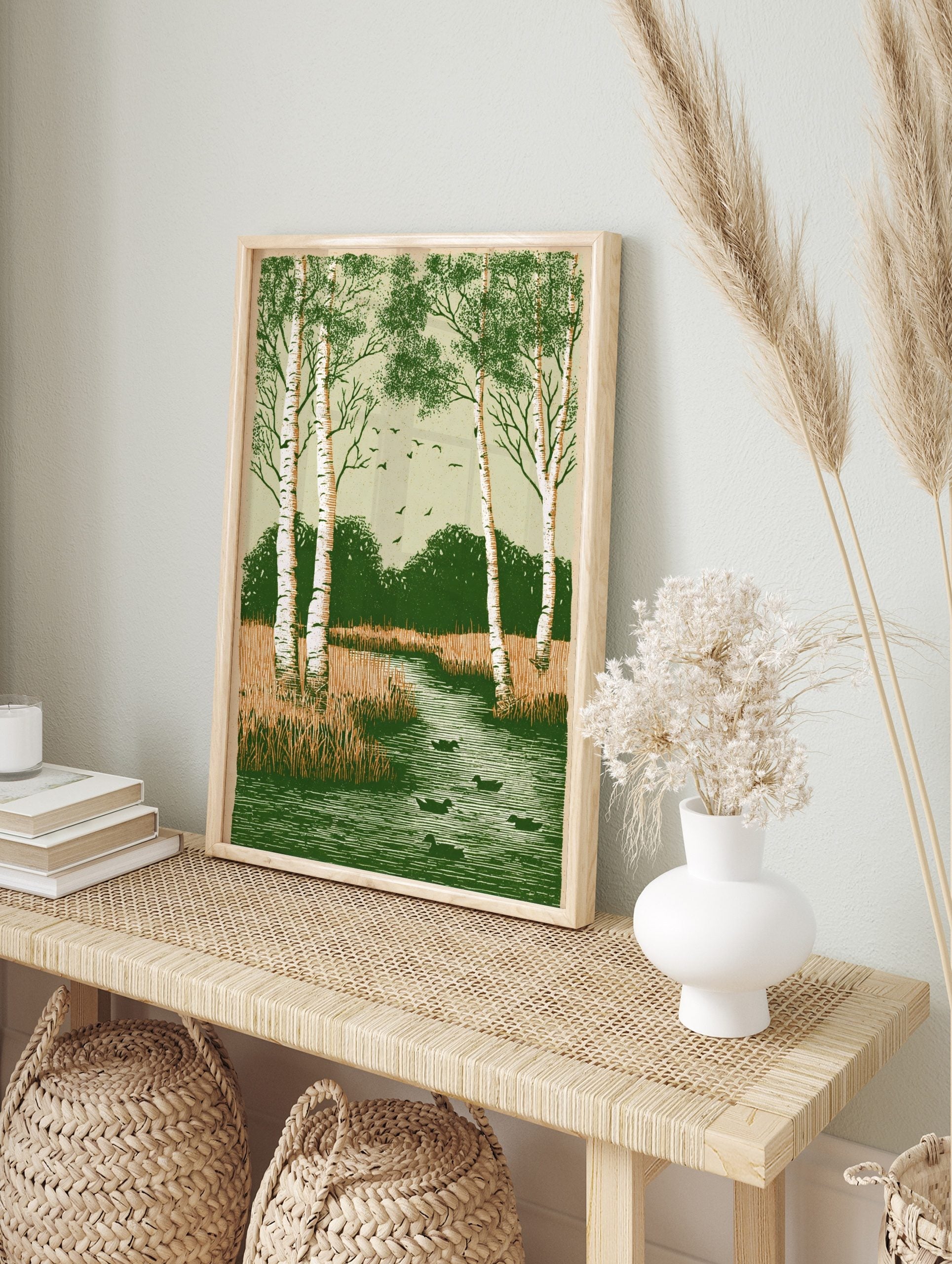 Illustrative print of birch trees, ducks in a river, marsh grass, and flying birds in green, in an alternate framed mockup