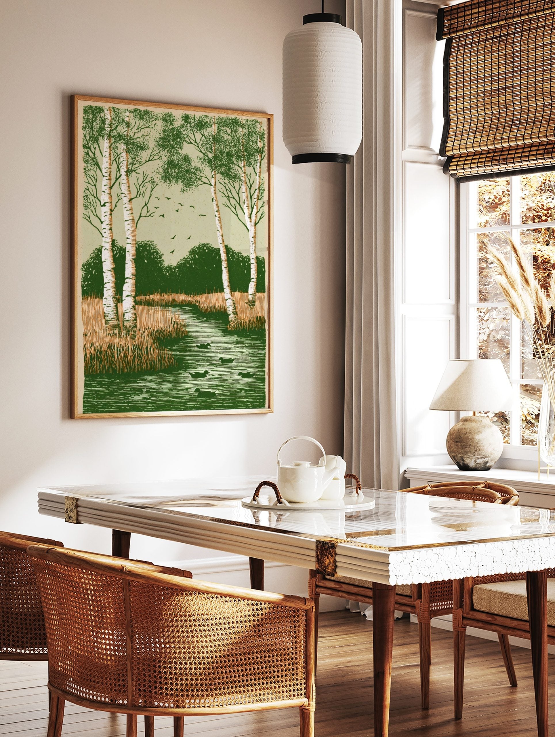 Illustrative print of birch trees, ducks in a river, marsh grass, and flying birds in green and, in a styled room mockup