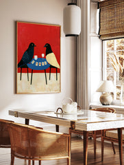 Illustrative art print of two birds playing cards on a blue table against a solid red background, in a styled room mockup