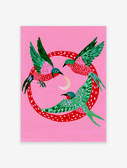 Three stylized birds with green and pink wings flying around a crescent moon inside a red polka-dot circle on pink paper