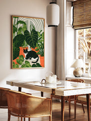 Black and white cat sitting among large green house plants in terracotta pots, botanical, in a styled room mockup