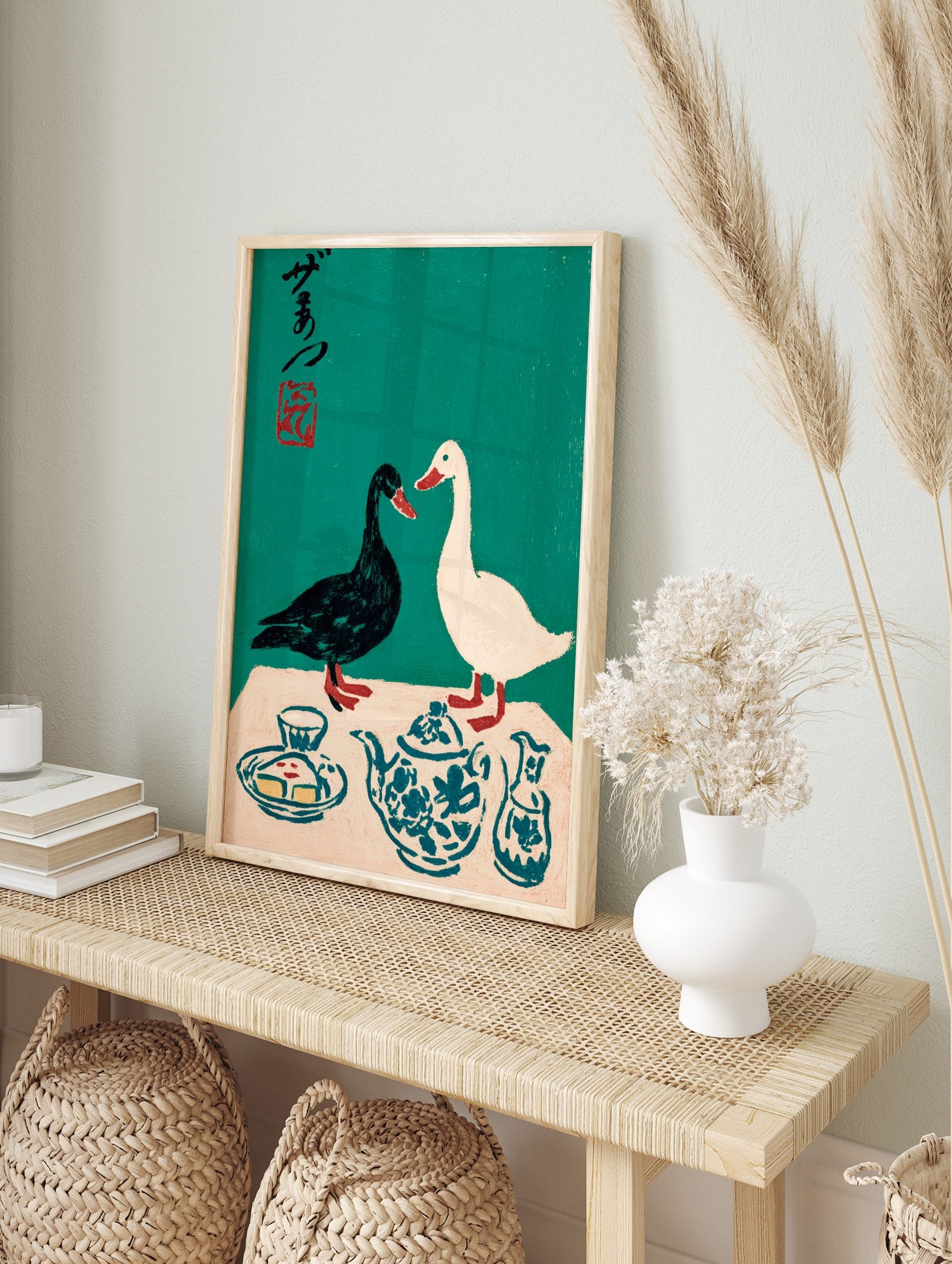 Illustrative print of black and white ducks with a blue patterned teapot and Japanese, in an alternate framed mockup