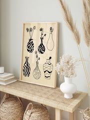 Black and white line art print featuring six illustrative vases with botanical elements on a, in an alternate framed mockup