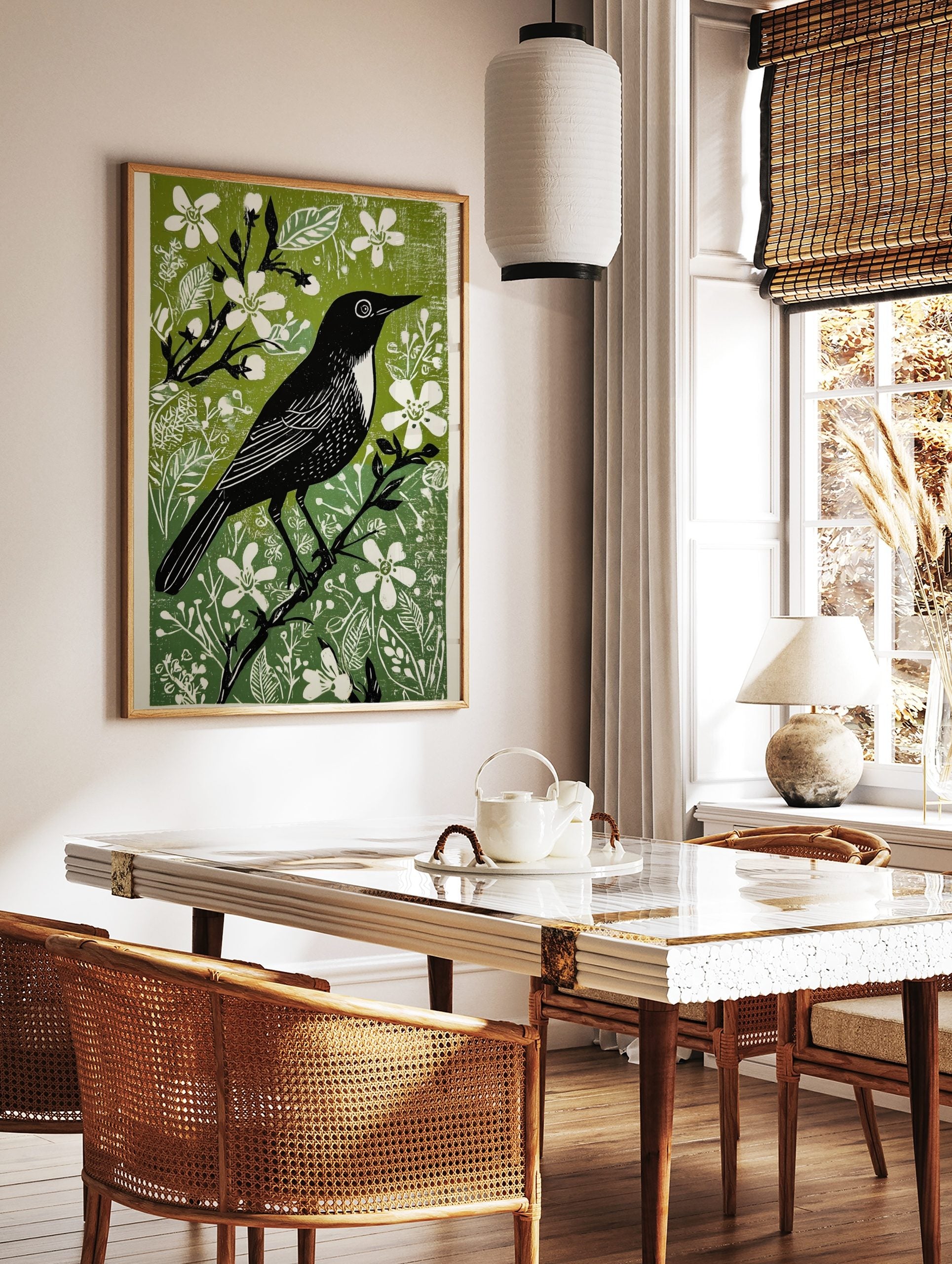 Black bird with white chest on a branch, surrounded by white flowers and green leaves, in a linocut, in a styled room mockup