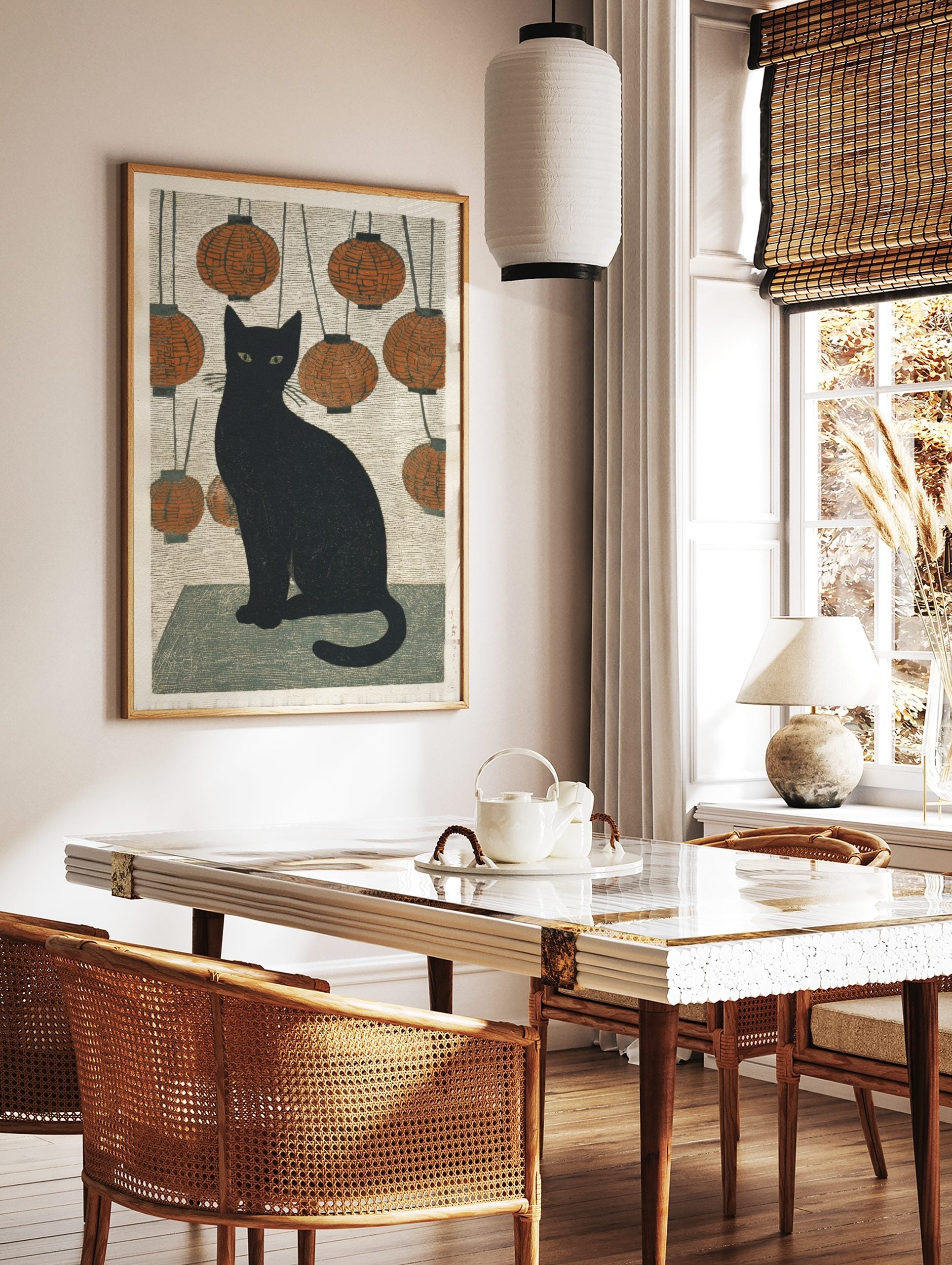 Black cat with green eyes sitting amidst hanging orange lanterns in Japanese woodblock style print, in a styled room mockup