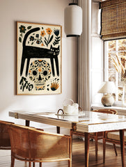 Illustrative black cat and sugar skull wall art with orange and blue floral elements on a cream, in a styled room mockup