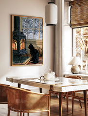 Illustrative print of a black cat sitting before a glowing wood-burning stove with a snowy winter, in a styled room mockup