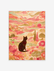 Illustrative print of black cat in colourful landscape with pink hills, green trees, and distant villas