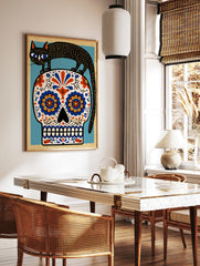 Black cat standing on a decorative sugar skull with vibrant blue and orange floral patterns, in a styled room mockup