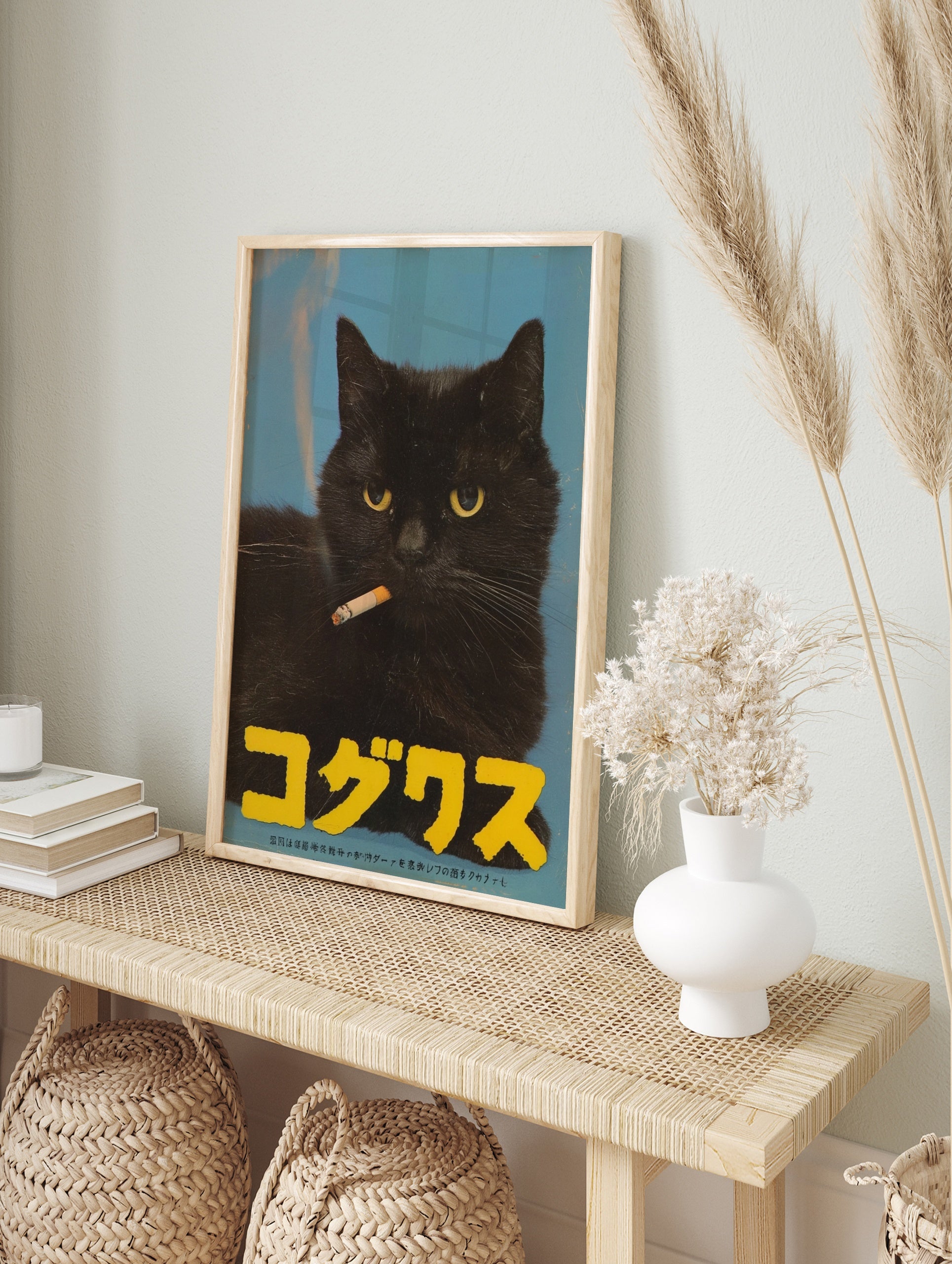 Close-up of a black cat smoking a cigarette on a blue background with large yellow Japanese, in an alternate framed mockup