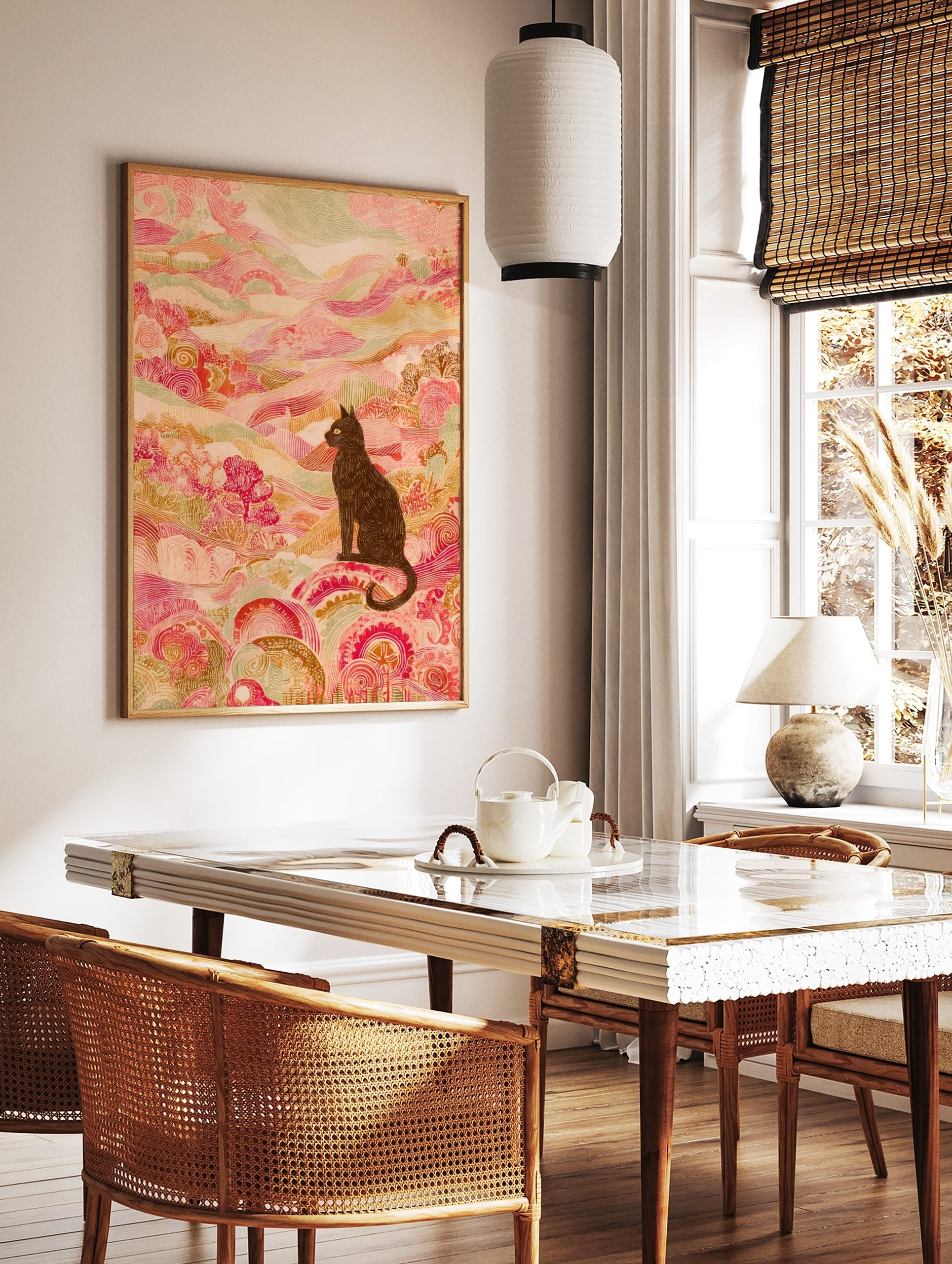 Illustrative black cat with yellow eyes in an ornate pink and green patterned landscape art print, in a styled room mockup