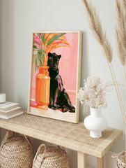 Painterly art print of a black panther sitting next to an orange vase with tropical leaves, in an alternate framed mockup