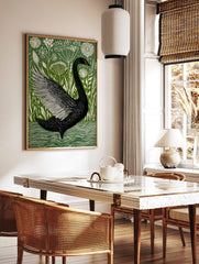 Black swan with fanned wing in illustrative green and white botanical art print, swimming in water, in a styled room mockup