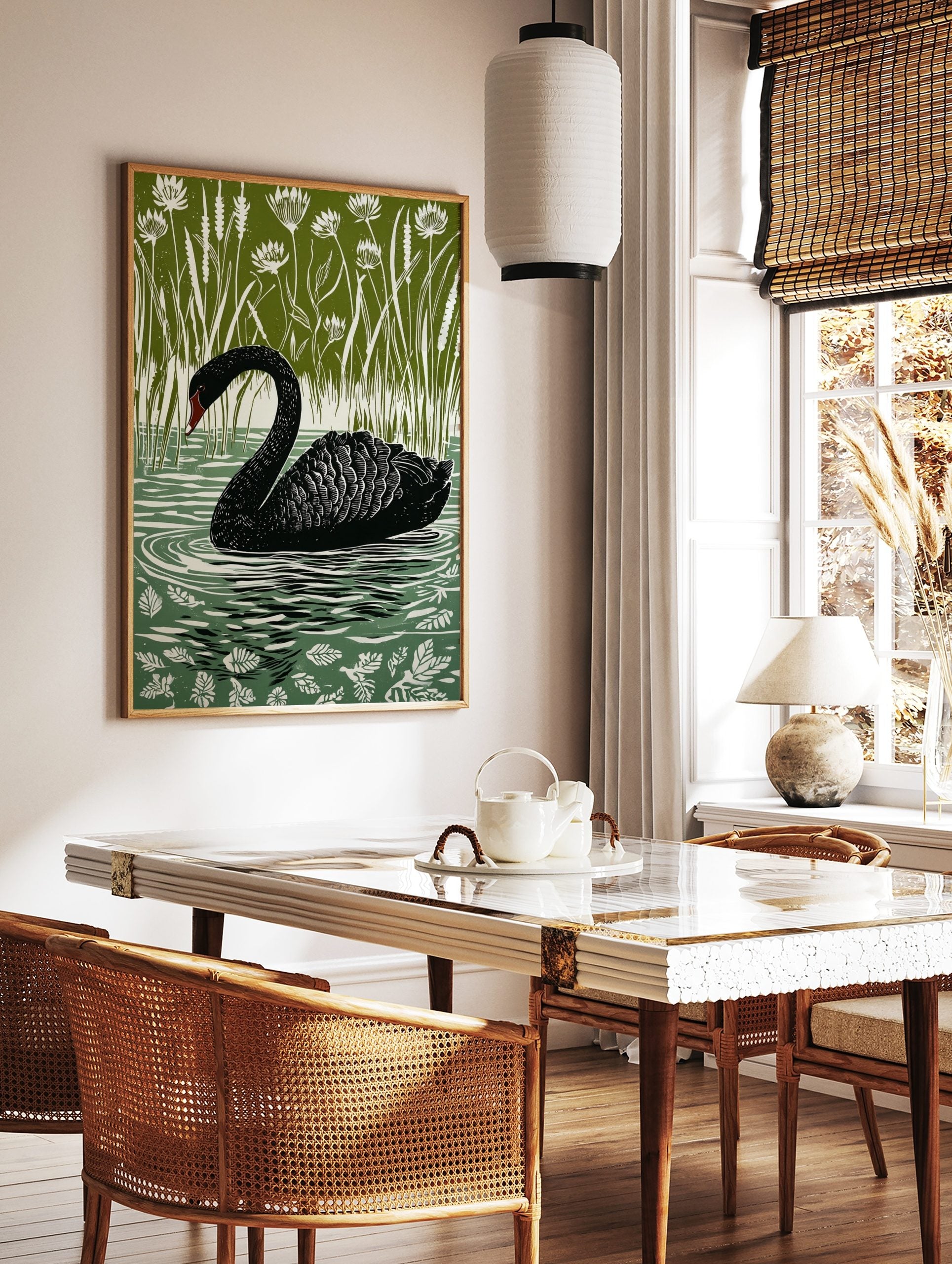 Black swan swimming in water with white ripples, surrounded by tall green reeds and white flowers, in a styled room mockup