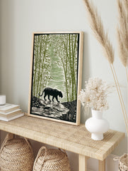 Black tiger with stripes walking through a dense green bamboo forest, river in foreground, in an alternate framed mockup